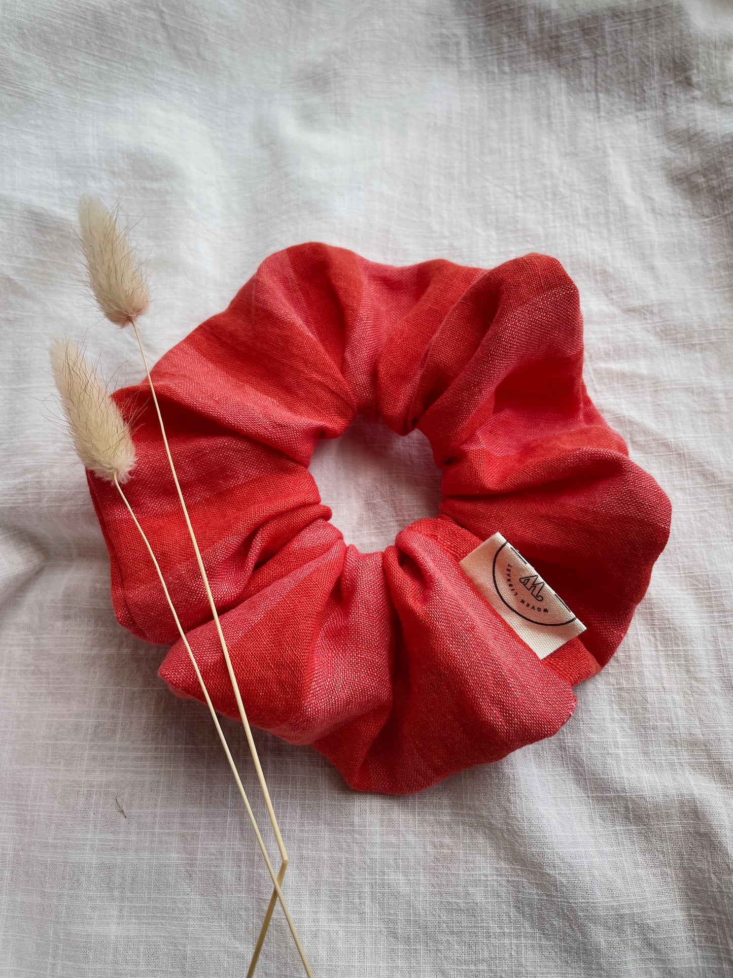 Stripey red scrunchie oversized sitting on white fabric