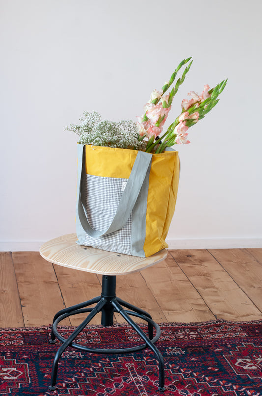 Yellow Cotton bag placed on a chair and filled with flowers
