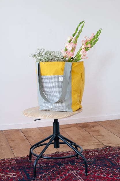 Yellow bag with check pockets and grey straps made from dry oilskin cotton